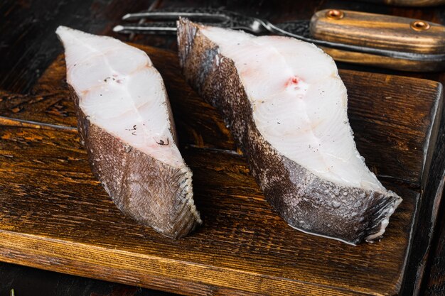 Fresh steak raw fish halibut set, with ingredients and rosemary herbs, on old dark  wooden table background