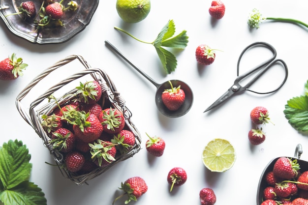 Fresh strawberries in a basket on a white wooden table