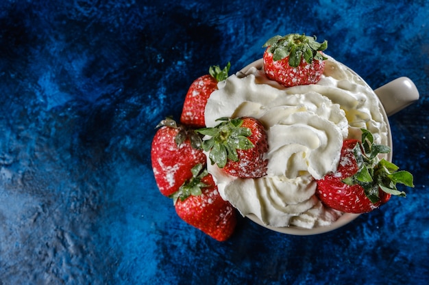 Photo fresh strawberries on a blue textured base