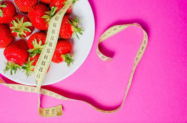 Fresh strawberries and centimeter tape. The concept of proper nutrition. Dietary food.