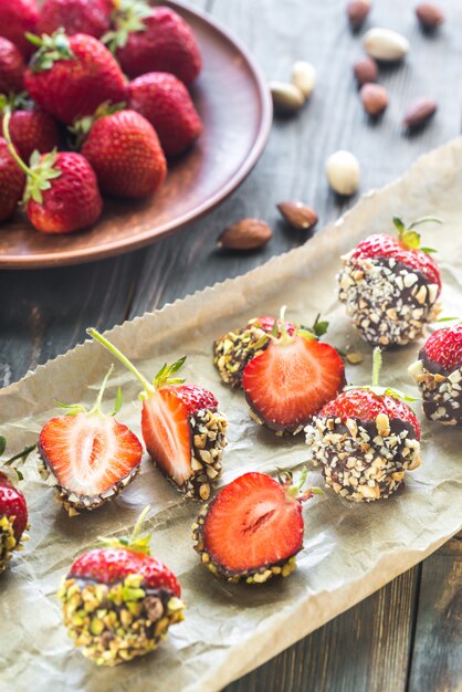 Fresh strawberries covered with dark chocolate and nuts