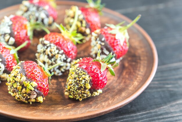 Fresh strawberries covered with dark chocolate and nuts