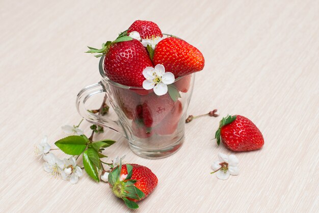 Fresh strawberries in a glass Cup on a wooden table