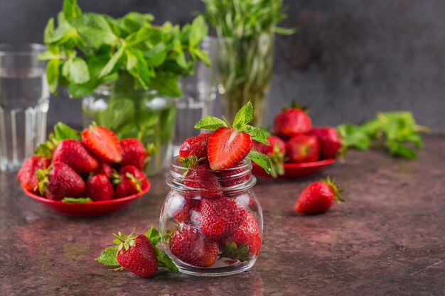 Fresh strawberries on glass jar close up