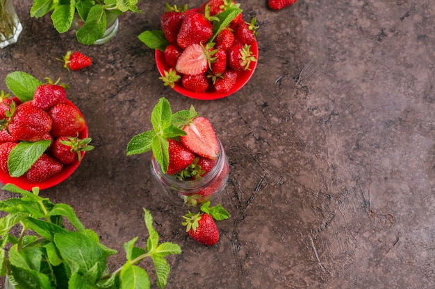 Fresh strawberries on glass jar top view. Healthy food on dark table mockup