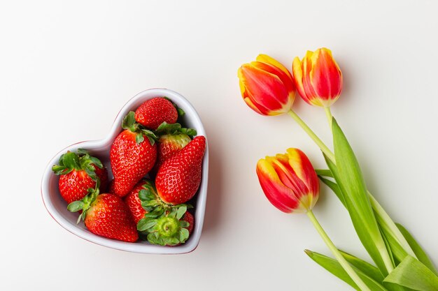 Photo fresh strawberries in heart bowl