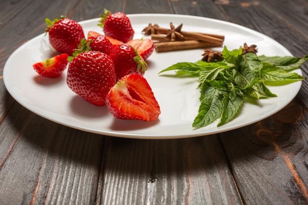 Fresh strawberries and mint on a white plate