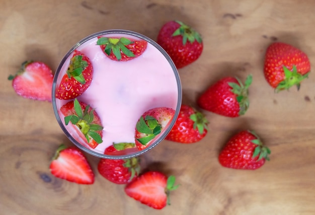 Photo fresh strawberries and strawberry yogurt on wood background