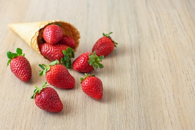 Fresh strawberries in a waffle cone on a light background