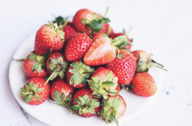 테이블에 하얀 접시에 신선한 딸기, 붉은 익은 딸기