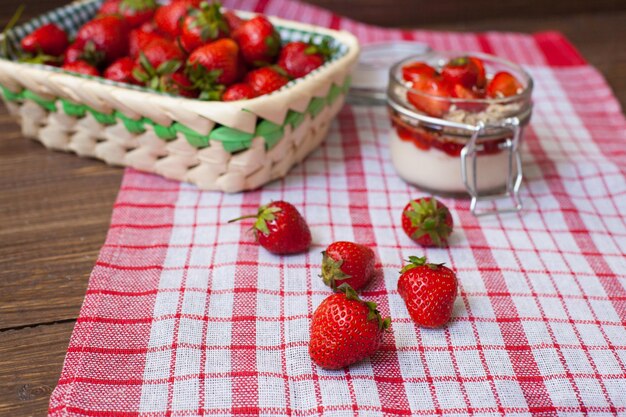 Fresh strawberries with cream and oat flakes in the glass bowl for preparing tasty lunch