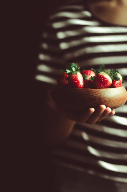 Fragole fresche in una ciotola di legno