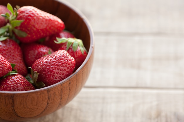 Fresh strawberries in a wooden bowl.