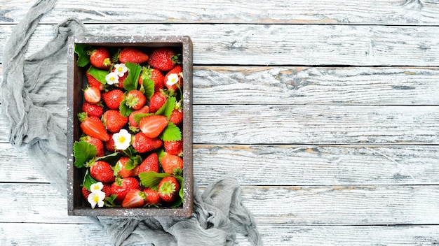 Photo fresh strawberries in a wooden box berries top view free space for your text