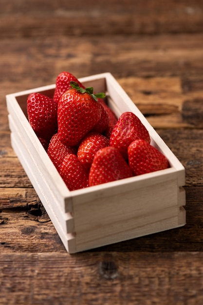 Fresh strawberry in basket on wooden table