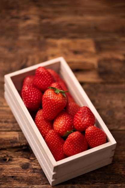 Fresh strawberry in basket on wooden table