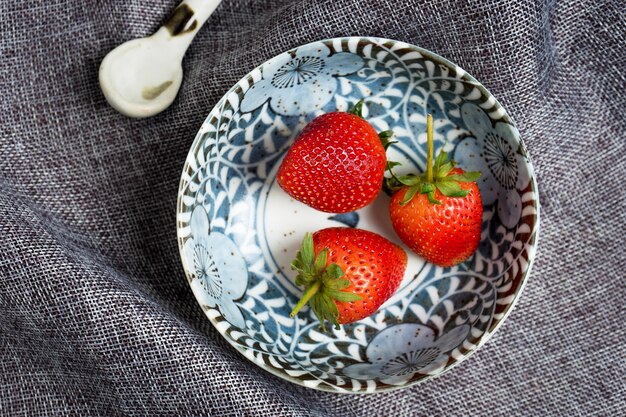 Fresh Strawberry in ceramic bowl on gray dish cloth