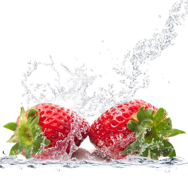 Fresh strawberry falling in water