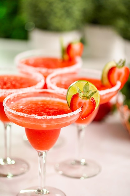 Коктейль Fresh Strawberry Margarita, украшенный свежей клубникой и лаймом.