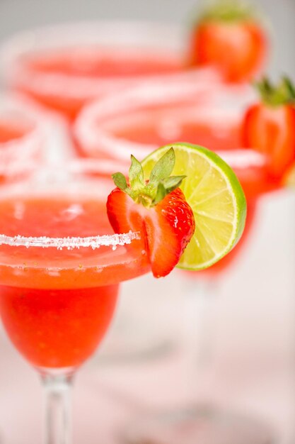 Коктейль Fresh Strawberry Margarita, украшенный свежей клубникой и лаймом.