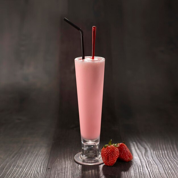 Fresh Strawberry Milkshake with straw served in glass isolated on table side view healthy morning drink