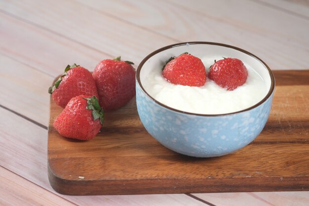 Fresh strawberry and yogurt in a bowl on table