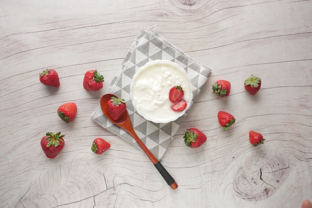 Fresh strawberry and yogurt in a bowl on table