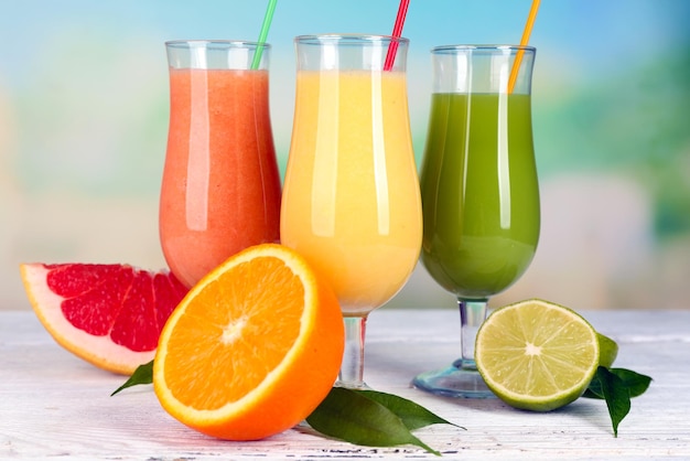 Fresh summer cocktails on wooden table on bright blurred background