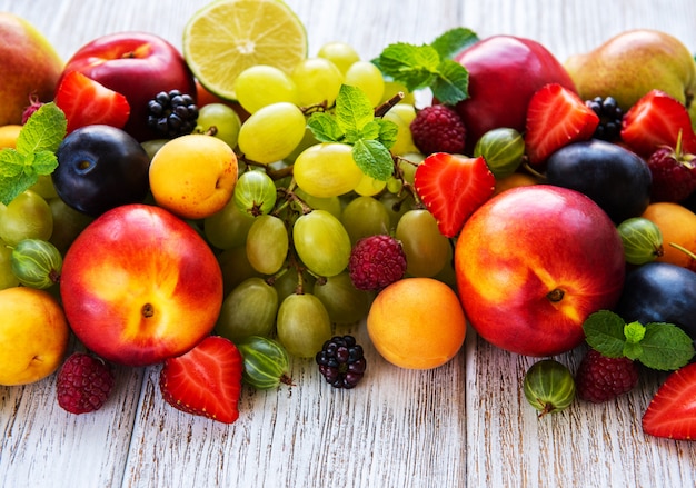 Frutta e bacche fresche di estate su una tavola di legno bianca