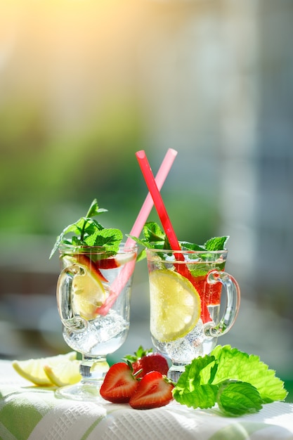 Fresh summer healthy drink with lemon and strawberries with ice.