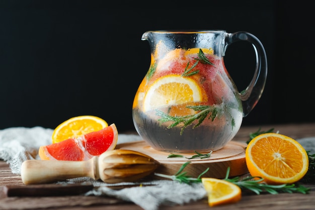 Fresh summer lemonade with grapefruit and rosemary on an old wooden table. Summer concept.