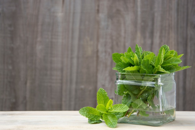 Foto menta fresca estiva fondo in legno, copia spazio.