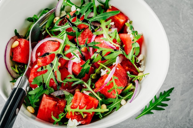 Fresh summer salad watermelon with feta arugula onion pine nuts and balsamic sauce