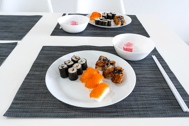 Fresh sushi and rolls in a white plate. Sushi lunch.