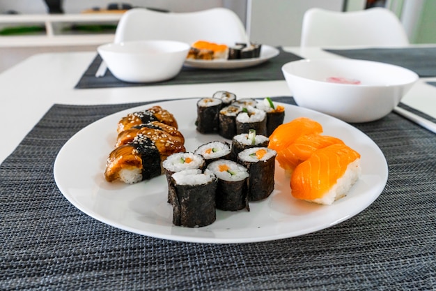 Fresh sushi and rolls in a white plate. Sushi lunch.