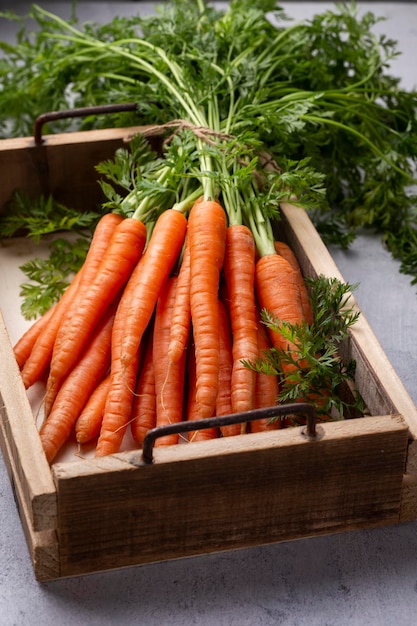 Свежая и сладкая морковь на деревянной коробке.