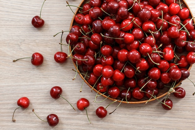 Fresh sweet Cherry on a wooden plate on a table. 