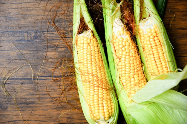 Fresh sweet corn ears on wooden 