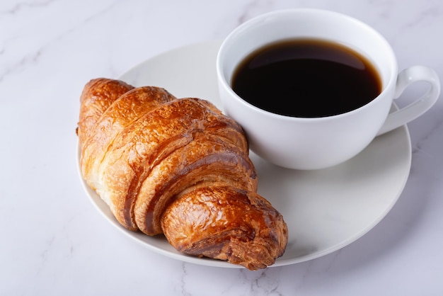 朝食に焼きたての甘いクロワッサンとコーヒー