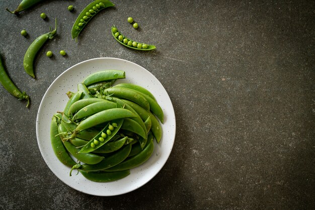 fresh sweet green peas on white plate