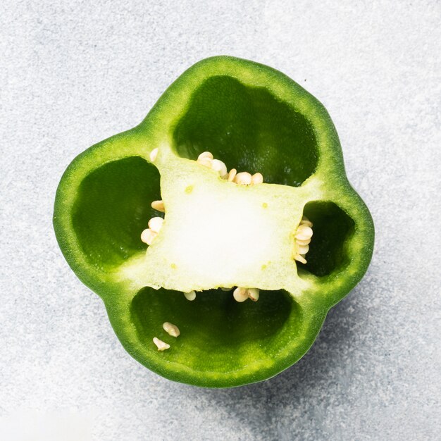 Fresh sweet green pepper in section on a grey concrete