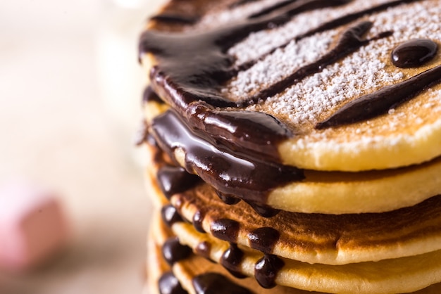 Fresh sweet pancakes with chocolate jam, cinnamon sticks and marshmallows.