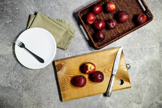 Fresh sweet ripe peaches in basket and wooden some pieces on cutting board on gray grunge background