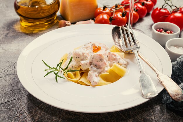 Fresh Tagliatelle pasta with Salmon in a cream sauce in white plate