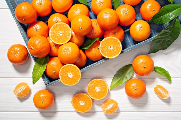 Fresh tangerine fruits with leaves on wooden table