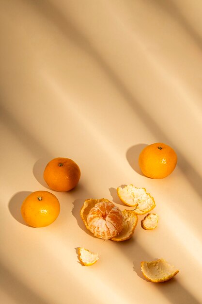 Fresh tangerines under the rays of sunlight on a beige background