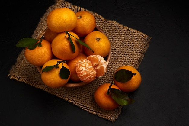 Fresh tangerines with leaves in a bowl