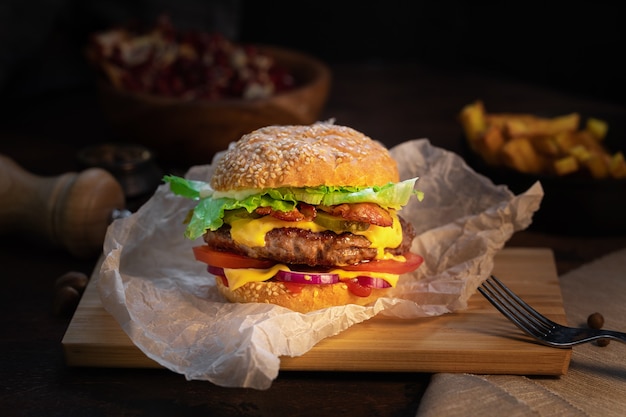 Fresh tasty burger and french fries on wooden table