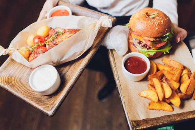 Fresh tasty burger and french fries on wooden table.