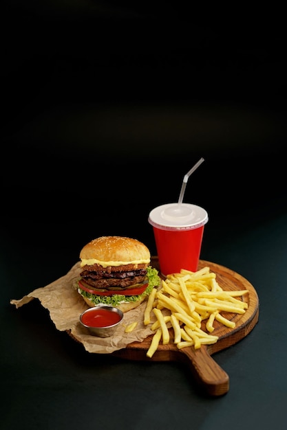 Fresh tasty burger and french fries on wooden table